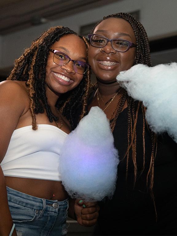 Two students smiling with cotton candy