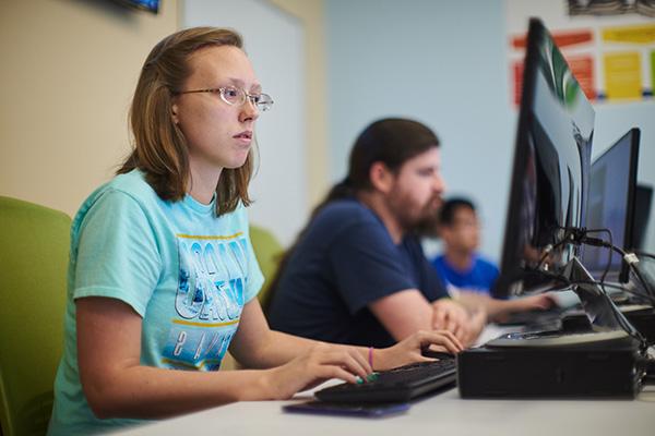 三个软件设计专业的学生在计算机实验室里练习编程